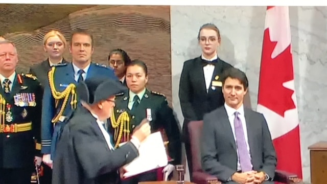 Formal ceremony with Canadian flag and officials — civic engagement